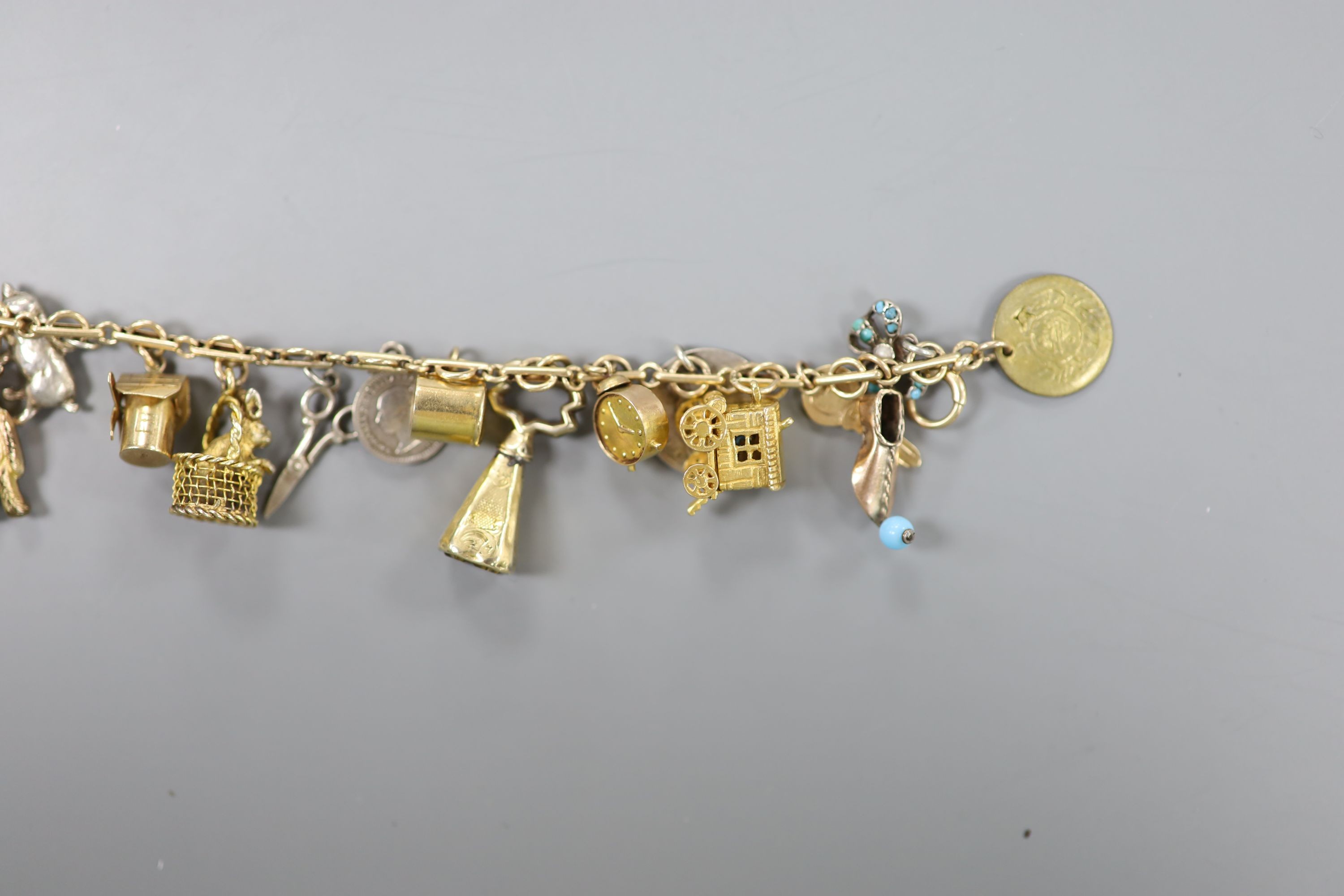 A 9ct charm bracelet, hung with assorted charms, gross weight 38.1 grams.